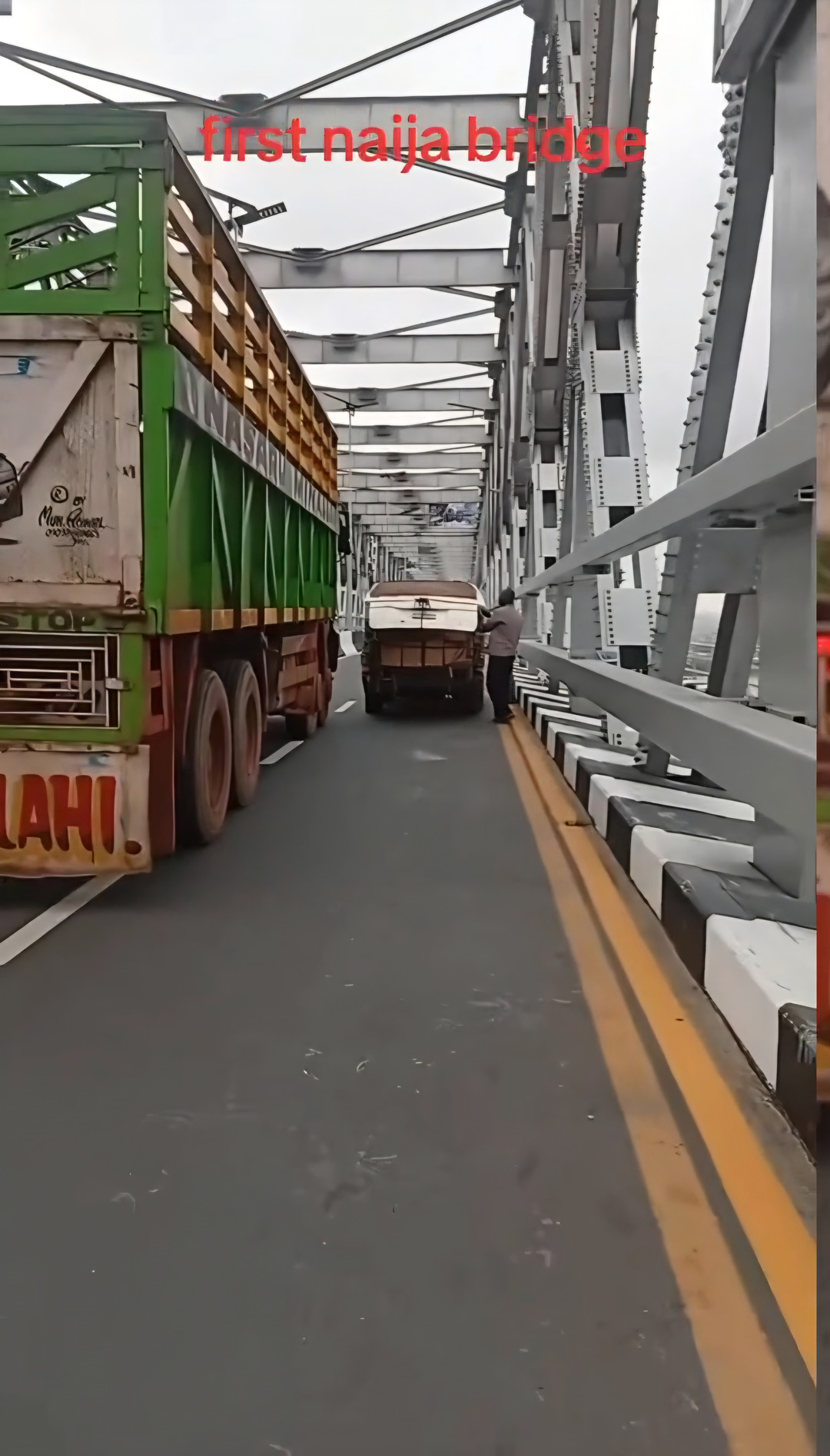 Video Of A Large Truck Going Past A Broken Down Minibus On The Niger Bridge.