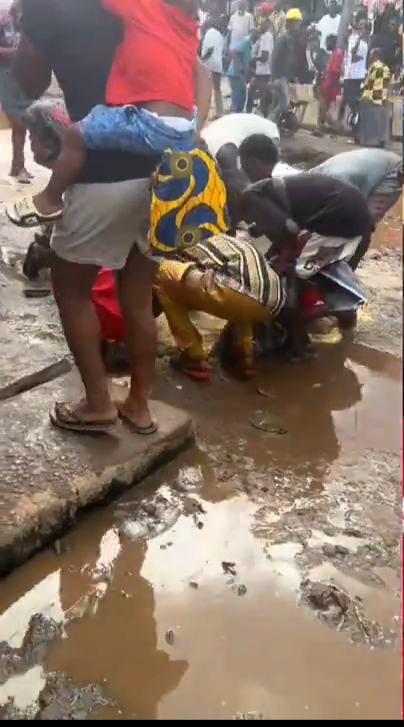 Lady Reacts As Nigerians Scoop Rice From Muddy Street In Benin City (Photos/Vid